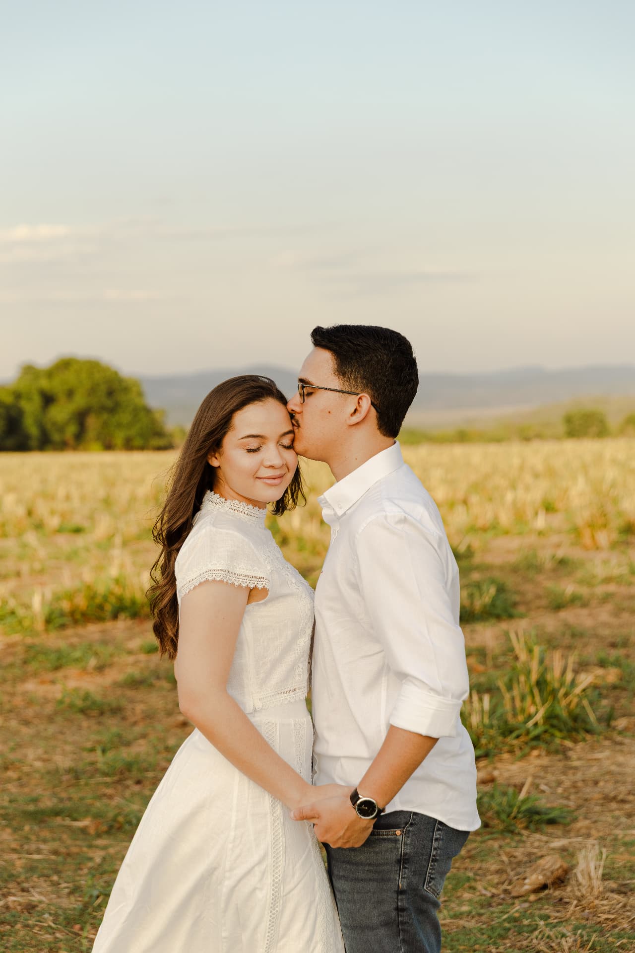 Jonas beijando Geovanna no campo ao pôr do sol
